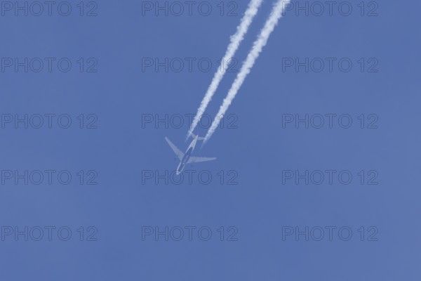Jet passenger aircraft of Delta airlines flying in a blue sky with contrails or vapour trails