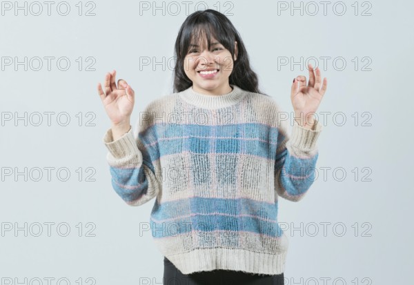 Smiling female interpreter gesturing OK in sign language. Smiling asian girl gesturing okay in