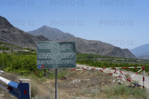A sign and a barrier are on a road with safety warnings, sign on the M17 road that runs along the