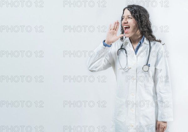 Female doctor shouting an announcement isolated. Young doctor shouting a promotion on isolated