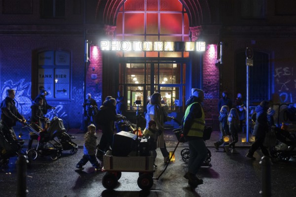 Participants with lanterns and strollers parade in front of the Arminiusmarkthalle during the