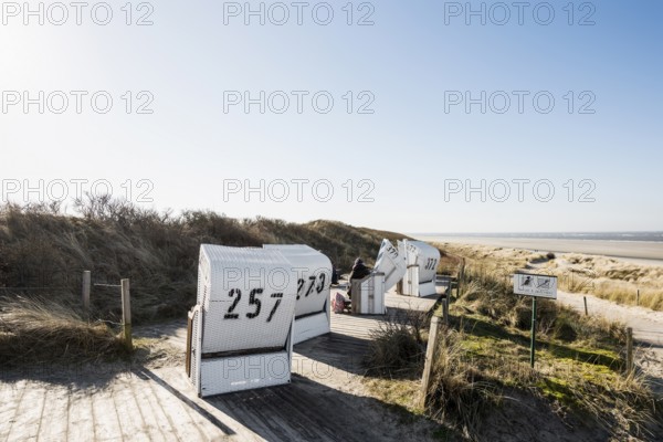 Beach chairs in the dunes and blue sky in winter, Spiekeroog, East Frisian Islands, Lower Saxony,
