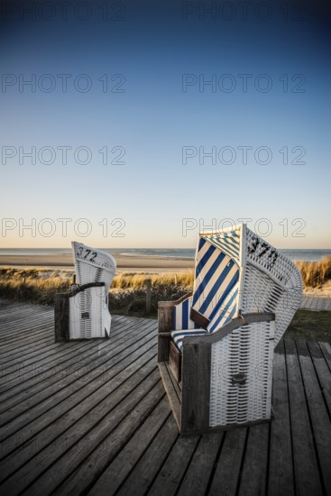 Beach chairs in the dunes and blue sky in winter, sunset, Spiekeroog, East Frisian Islands, Lower