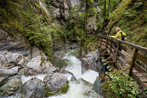 Female hiker on wooden walkway on the Diosaz mountain river in the gorge, Gorges de la Diosaz, Les