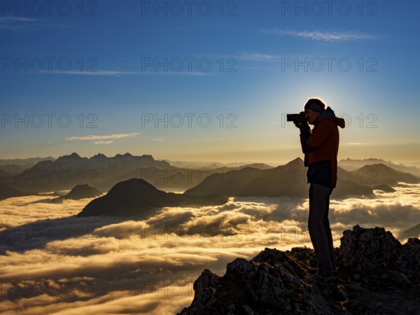 Photographer in evening light at the summit, view of an alpine panorama, Hochstaufen, Chiemgau