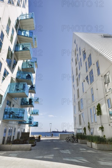 Distinctive white residential complex, turquoise balconies against blue sky, pyramid-shaped