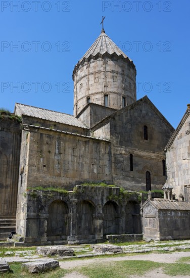 Monumental monastery complex with characteristic tower and stone architecture under a blue sky,
