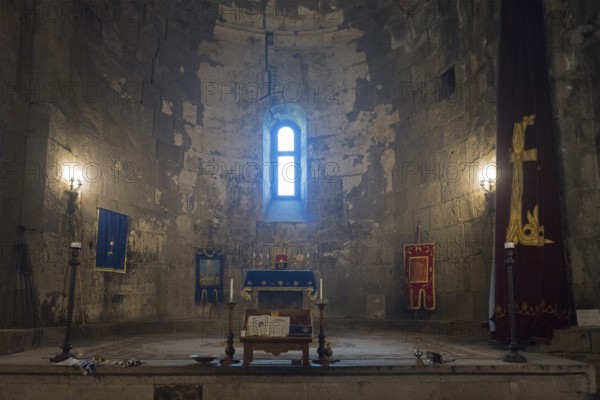 Illuminated church interior with altar, window and candles, filled with sacred atmosphere and
