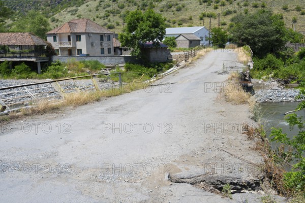 A dilapidated bridge crosses a river in a small rural village, bridge over the Debed River, Ayrum,