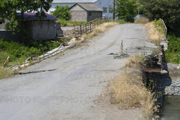 An old, damaged bridge crosses a small river in a rural area, bridge over the Debed River, Ayrum,