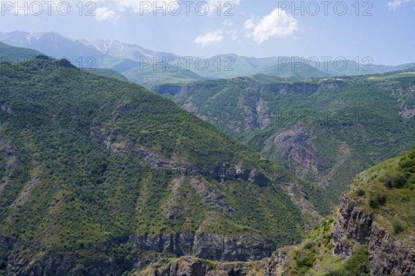 Green mountains with scattered clouds in the sky, peaceful and natural surroundings, view from