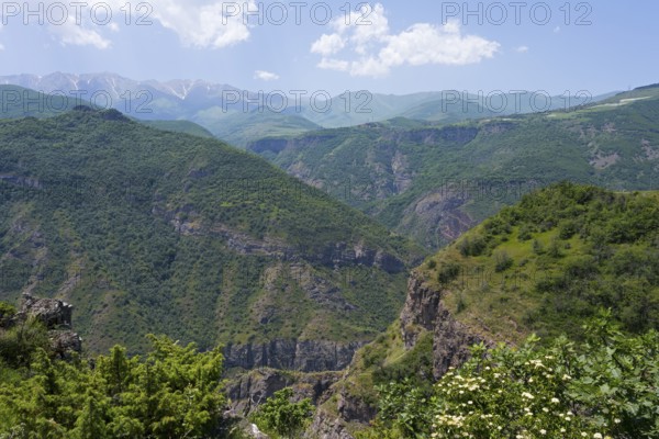 Green mountains under clear sky with white clouds, idyllic and peaceful atmosphere, view from the