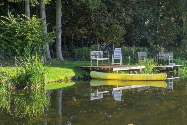 A jetty with benches and a yellow canoe on a quiet river, Dinkel River, Heek-Nienborg, Münsterland,