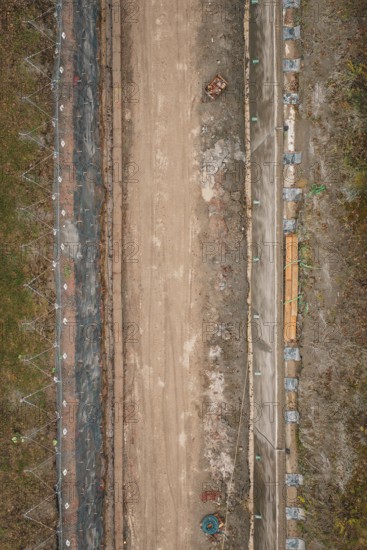 Vertical view of a construction site with earthworks and building materials along the route,
