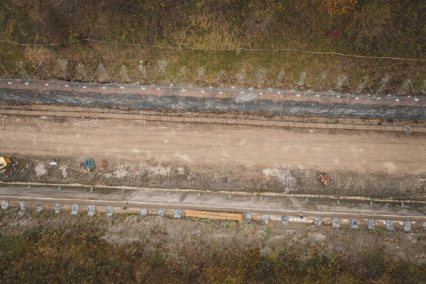 Aerial view of a construction site in an autumn area with construction along a path, construction