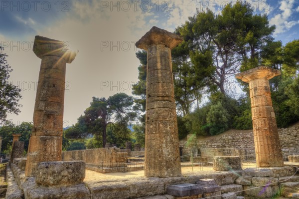 Temple of Hera, ancient Greek ruins with columns, illuminated by sunbeams, surrounded by trees,