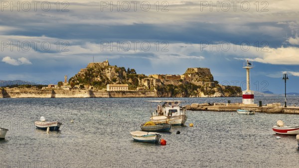 View of an island with fortress and small boats in the water under cloudy sky, UNESCO World