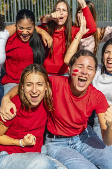 Diverse group of enthusiastic women celebrating and cheering for their favorite team at a sporting
