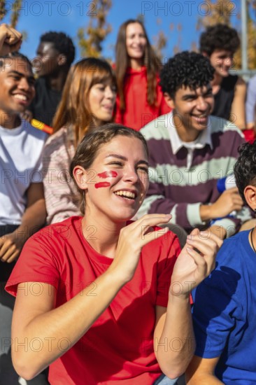 Young diverse friends and enthusiastic sports fans are cheering and clapping, showing excitement
