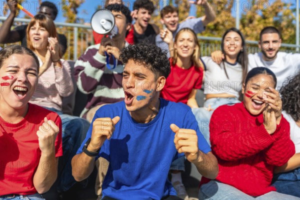 Multiracial young people celebrating and cheering passionately in a stadium, showing excitement and