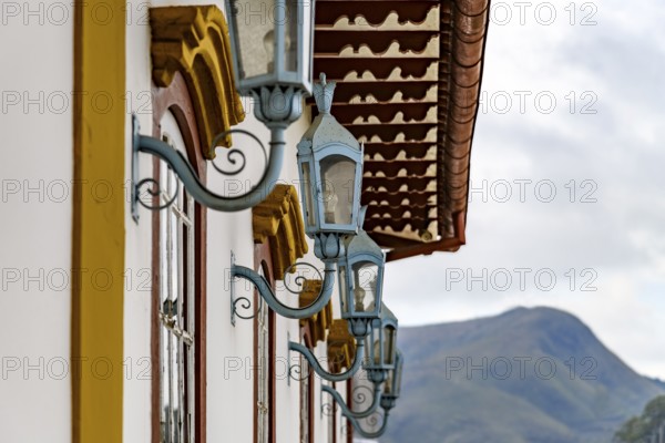 Several antique metal lanterns decorating the historical facade of a colonial-style house in the
