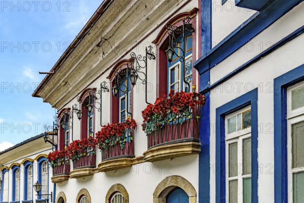 Facade of an old colonial-style houses with flowered balconies in the city of Ouro Preto, Minas