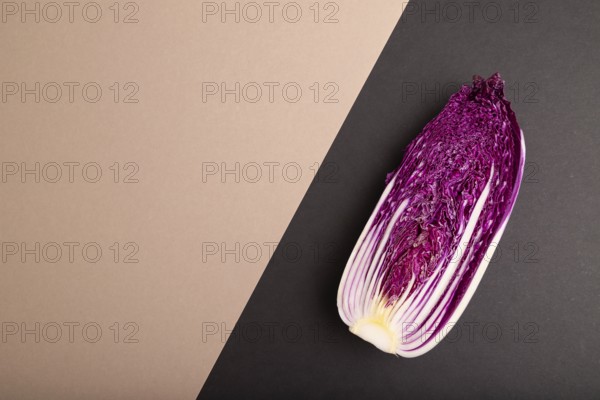 Purple Chinese cabbage on brown and black pastel paper background, top view, flat lay, copy space,