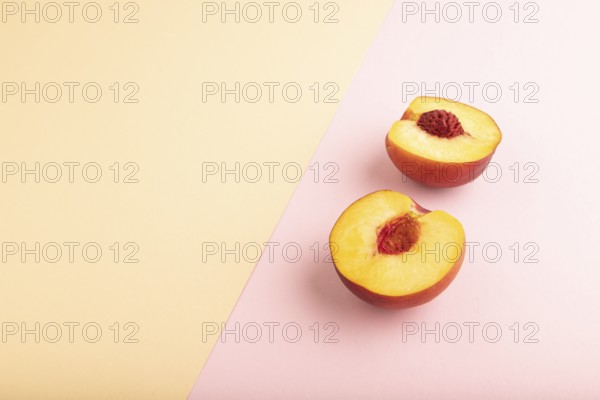 Peach Cut in half on orange and pink paper pastel background. Side view, copy space. healthy food,