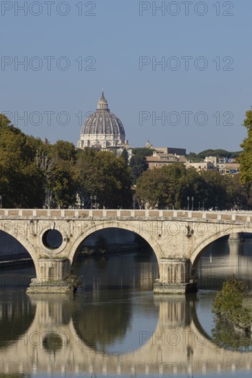 Bridge over the river Tiber with the dome of St. Peter's Basilica in the Vatican city in the