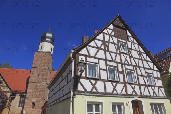 Half-timbered house and tower of the Catholic Church, town of Heideck in the district of Roth,