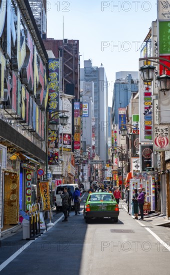 Street scene, lots of colorful signs of shops, restaurants and bars in a street, Shinjuku City,
