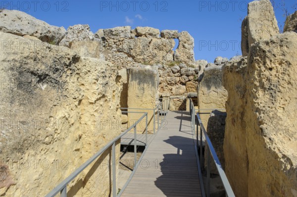View from secured walkway with railing through ruins remains of Ggantija temple, UNESCO World