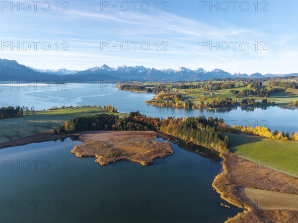 Wide landscape with calm lake, surrounded by autumn forests and alpine background, Illasbergsee,
