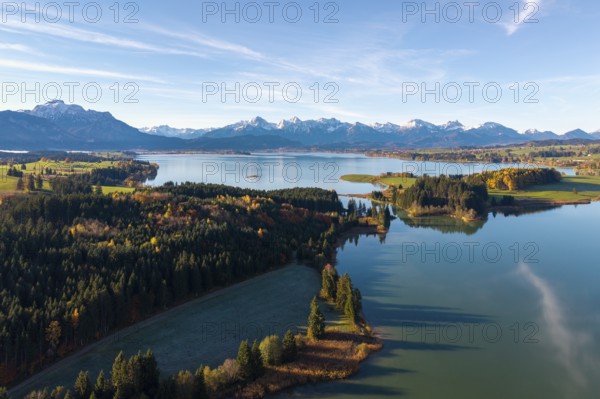 Autumn mountain landscape with a quiet lake and forests under blue sky, Illasbergsee, Forggensee,