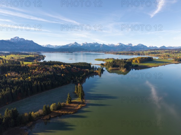 Clear reflections of a quiet lake surrounded by forests and mountains in autumn, Illasbergsee,