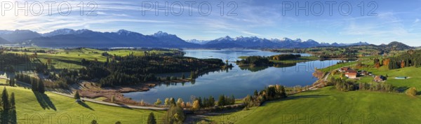 Panoramic view of a green landscape with lake and mountains under a clear sky, Illasbergsee,