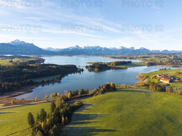 Rural scene with vast meadows and a lake, framed by mountains, Illasbergsee, Forggensee, near