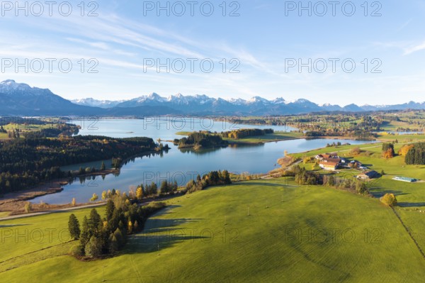 Picturesque landscape with a lake and mountains surrounded by green fields, Illasbergsee,