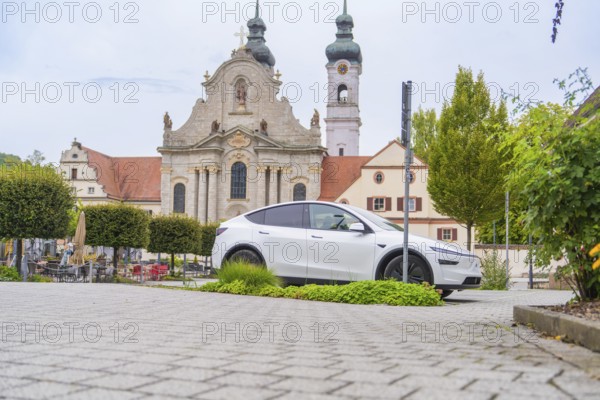 A modern car is parked in front of a historic church in the city center, ZFP Zwiefalten, Reutlingen
