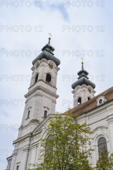 Two tall baroque church towers with crosses in the background of a cloudy sky, ZFP Zwiefalten,