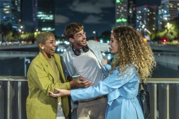 Diverse young adults laughing and bonding on a city bridge at night, candidly enjoying each other's