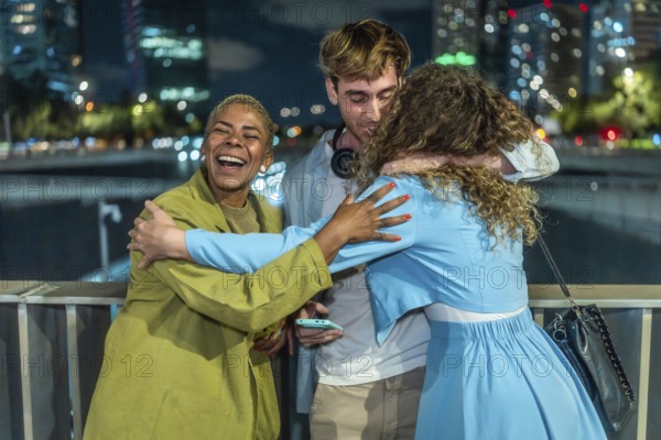 Diverse group of young adult friends expressing happiness and embracing each other, showing