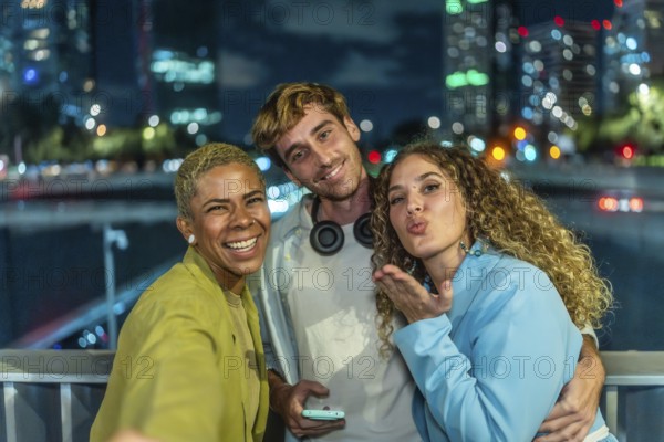 Diverse group of young adult friends enjoying a fun night out in the city, smiling and posing for a