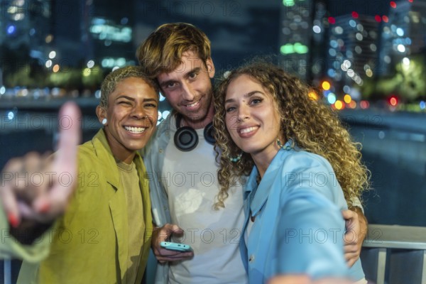 Three happy diverse friends are taking a selfie together, smiling at the camera and celebrating