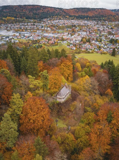 Viewing platform in an autumn forest with a view of a village below, Wehingen, Tuttlingen district,