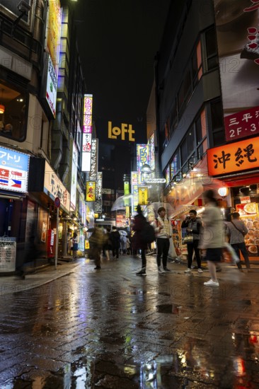 Busy pedestrian zone with many shopping centers and stores, illuminated with lots of neon signs at