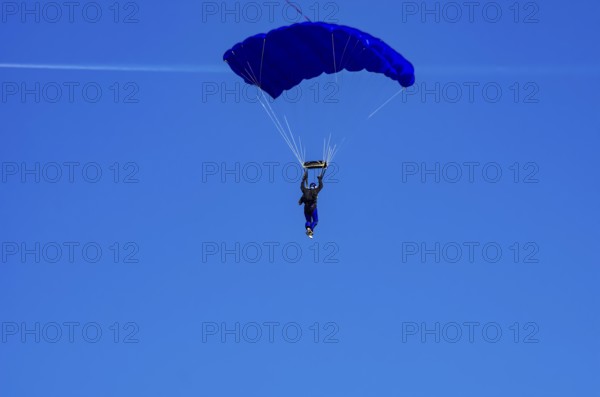 Skydivers during an aerial acrobatic performance as part of an air show at the Fliegerbergfest of