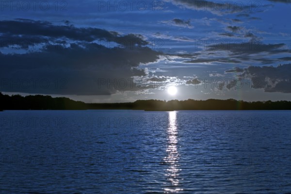 Atmospheric moonrise over Lake Gudelack, Lindow (Mark), Stechlin-Ruppiner Land nature park Park,