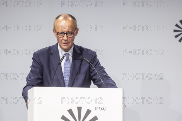 Federal Chancellor Friedrich Merz (CDU) . Portrait at the lectern with free text space.