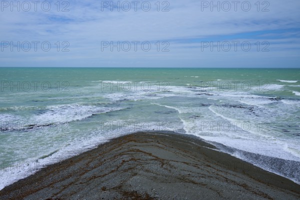 Sea with foaming waves and cloudy sky, Tuhawaiki Point Lighthouse or Jack's Point Lighthouse,